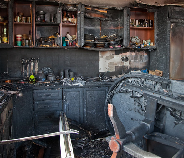 a fire damaged kitchen with soot covering the walls and counters