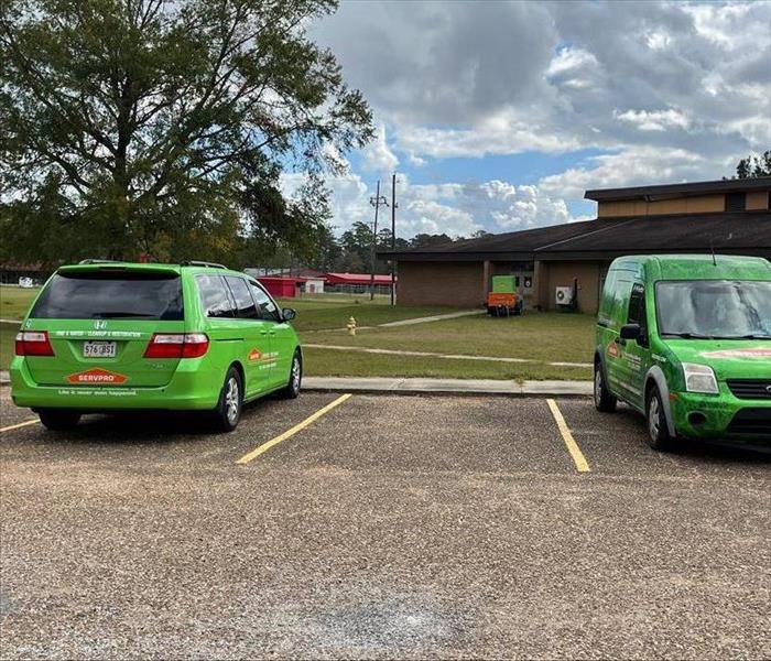 Two SERVPRO vehicles outside building.