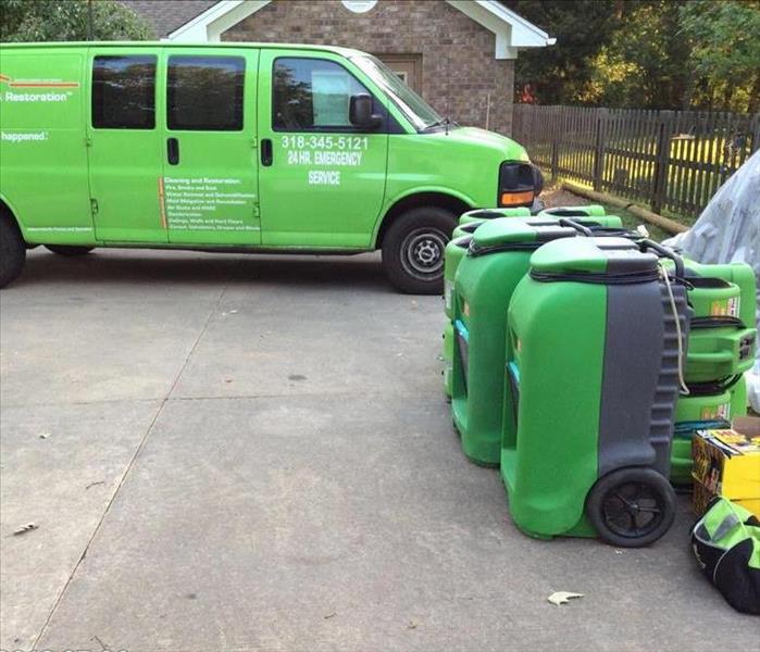 SERVPRO vehicle parked in front of home with equipment