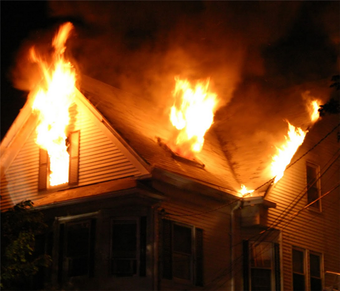 fire and smoke billowing from the windows of a house on fire